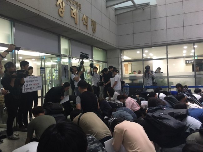 Mourners vow to mother of the deceased 19-year-old worker in front of the altar at Konkuk University Hospital, Saturday. (Ock Hyun-ju/The Korea Herald)