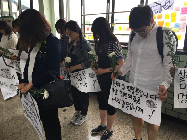 Citiznes pay a silent tribute for the deceased 19-year-old worker at Guui Station. (Ock Hyun-ju/The Korea Herald)