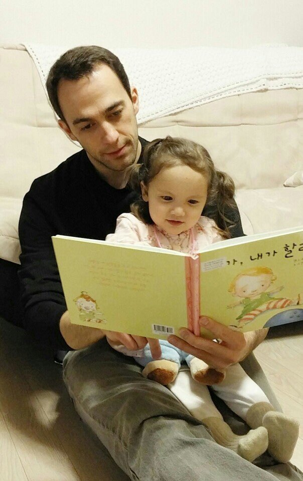 Shawn Morrissey reads with his daughter Ha-yoon before the surgery