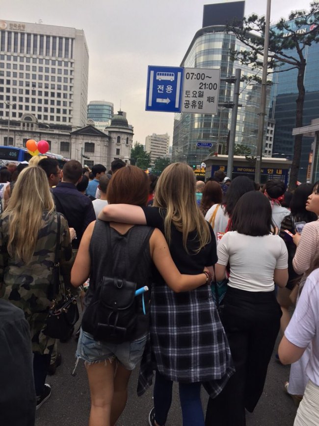 Two women put arms around each others' shoulders marching through central Seoul at the Pride Parade, Saturday. (Ock Hyun-ju/The Korea Herald)
