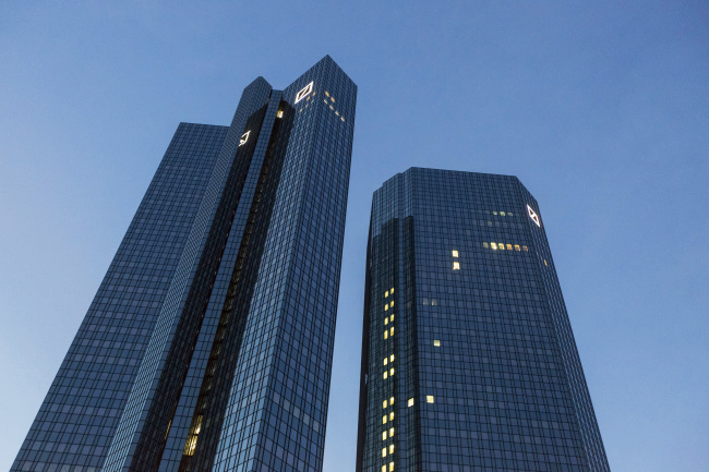 The twin tower skyscraper headquarters of Deutsche Bank AG stand at dusk in Frankfurt, Germany. Bloomberg