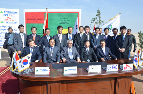 Officials from companies engaged in the project pose for a photograph in April 2014.