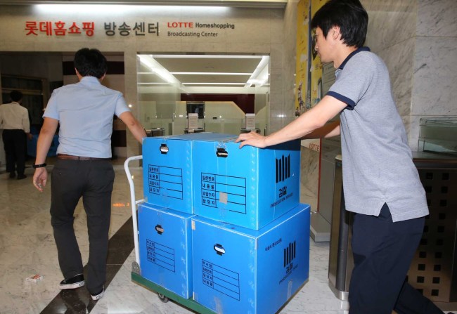 Prosecutors move seized documents from Lotte Home Shopping during a raid on June 10. (Yonhap)