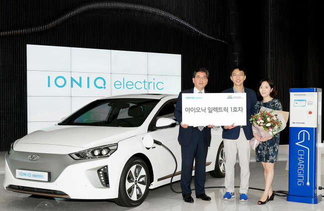 The first Korean consumer (center) of Hyundai Motor’s electric vehicle Ioniq Electric poses with the company’s domestic sales chief Chang Jae-hoon (left) on Wednesday at the company’s office in Gangnam-gu, Seoul. The all-electric model, which is able to drive up to 191 kilometers on a single charge, hit the market in June. (Hyundai Motor)