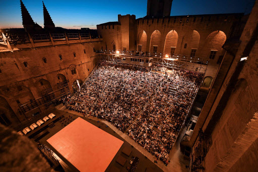 Spectactors attend “The damned” play by Luchino Visconti, directed by Ivo Van Hove on Wednesday in the courtyard of honor of the Palais des Papes in Avignon, southern France. (AFP-Yonhap)