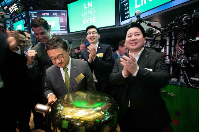 Line CFO Hwang In-joon (left), New York Stock Exchange President Tom Farley (second from left), Line Chief Global Officer Shin Jung-ho (third left), and Line chief strategy officer Jun Masuda ring a ceremonial bell as Line's IPO begins trading on the floor of the New York Stock Exchange on July 14. / Naver