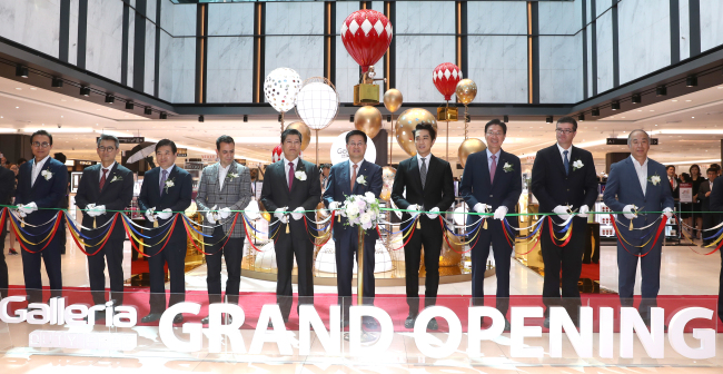 Hanwha Galleria president Hwang Yong-deuk (sixth from left) and actor Song Seung-hun (seventh from left) attend the opening ceremony for its duty-free shop in Yeouido’s 63 Building on Friday. Yonhap