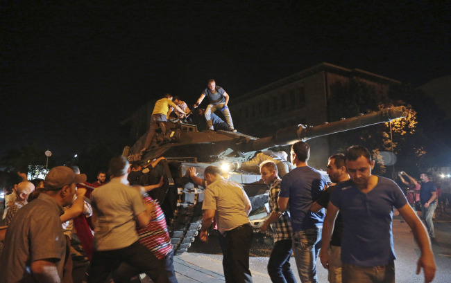 Turkish people attempt to stop a tank moving into position in Ankara, Turkey, late Friday, July 15, 2016. Members of Turkey's armed forces said they had taken control of the country, but Turkish officials said the coup attempt had been repelled early Saturday morning in a night of violence, according to state-run media.(AP-Yonhap)