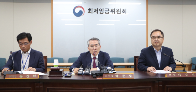 Minimum Wage Council Chairman Park Jun-sung (center) and other members of the council conduct a briefing at the Ministry of Employment and Labor in Sejong Saturday. (Yonhap)