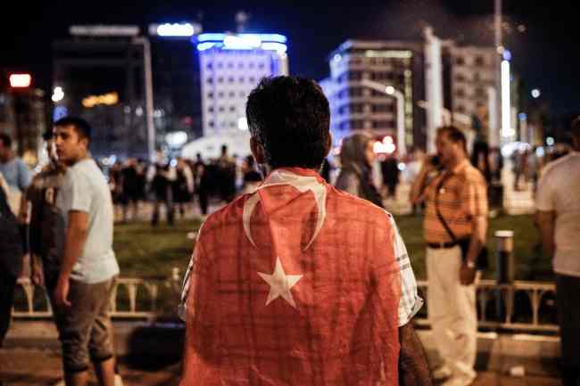 A man stays with a Turkish national flag at Taksim square in Istanbul on July 16, 2016. (AFP Photo)