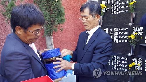 South Korean officials carry the remains of fishermen, which were buried in Spain decades ago, on Nov. 1, 2015.(Yonhap)