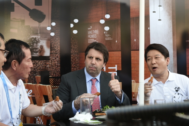 The U.S. ambassador to Korea, Mark Lippert, enjoys fried chicken at the event. (Visit Korea)