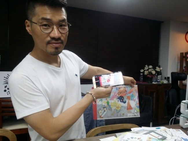 Circus Company CEO Park Sun-uk demonstrates AR technology with an envelope. The Korea Herald/Song Ji-won