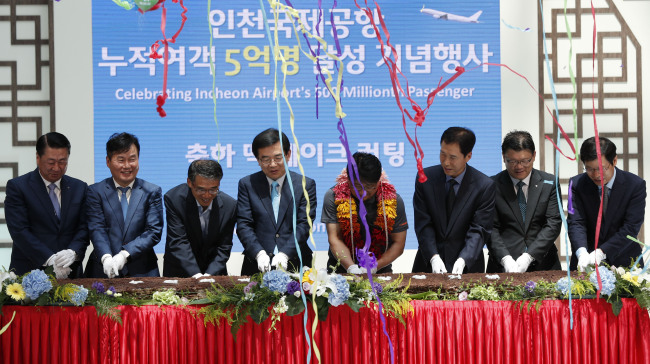 Incheon International Airport Corp. CEO Chung Il-young (fourth from left) and Kim Yong-geun (fifth from left), the airport’s 500 millionth flight passenger, attend a celebration at the airport Sunday. Yonhap