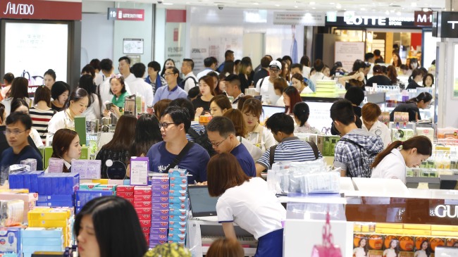 Tourists shop at Lotte Duty Free in Sogong-dong, Seoul. (Yonhap)