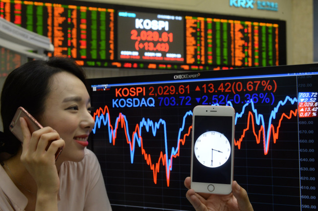 Cap: A worker makes a telephone call after the stock market closed at the Korea Exchange in Seoul on Aug. 1. Korea Exchange