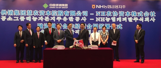 NongHyup Financial Chairman & CEO Kim Yong-hwan poses with his Chinese counterpart Yang Fenglu on Aug. 4 after signing a deal at the Chinese company’s office in Beijing, China. NH Financial Group