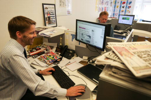 Reporters Darryl Smith (left) and Gavin Sherriff work on their final pieces in their office on Fleet Street, central London, on Aug. 5. (AFP)