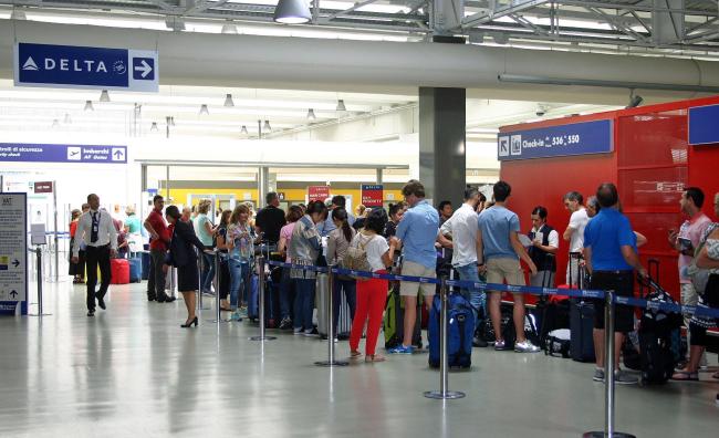 Passengers line up as they wait to board Delta Air Lines flights at Rome's Leonardo Da Vinci airport, Monday, Aug. 8, 2016. Delta Air Lines has grounded flights and predicted widespread cancellations Monday, disrupting the travel plans of thousands of passengers, after a power outage hit its computer systems globally. (AP-Yonhap)