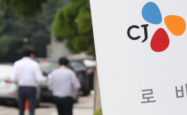 CJ Group employees walk alongside the group’s headquarters in Seoul (Yonhap)