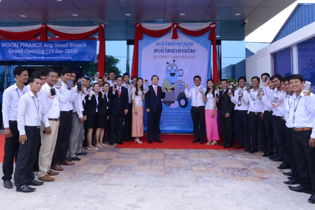 Woori Bank officials and local staff attend a ceremony to launch “WiBee Bank” to offer online loan applications and currency exchange services in Cambodia in September. (Woori Bank)