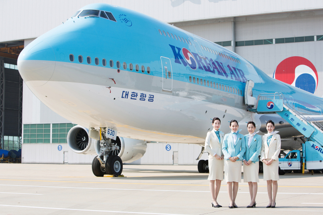 Flight attendants pose near a Korean Air plane in Incheon International Airport. (Korean Air)