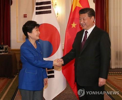 Photo taken on April 1, shows President Park Geun-hye (left) shaking hands with her Chinese counterpart Xi Jinping before their talks on the sidelines of the Nuclear Security Summit in Washington, D.C. (Yonhap)