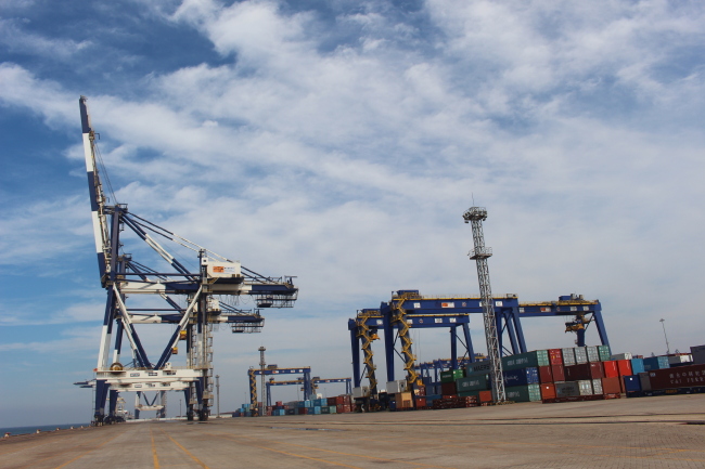 Containers are piled next to a crane at a Yantai port. (Yoon Min-sik/The Korea Herald)