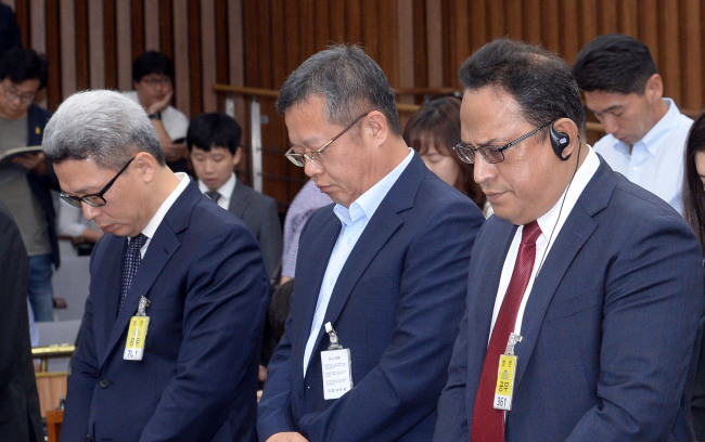 Oxy CEO Ataur Safdar (right) pays a silent tribute while attending a parliamentary questioning on the toxic humidifier disinfectant case as a witness on Aug. 29. The Investor/Ahn Hoon