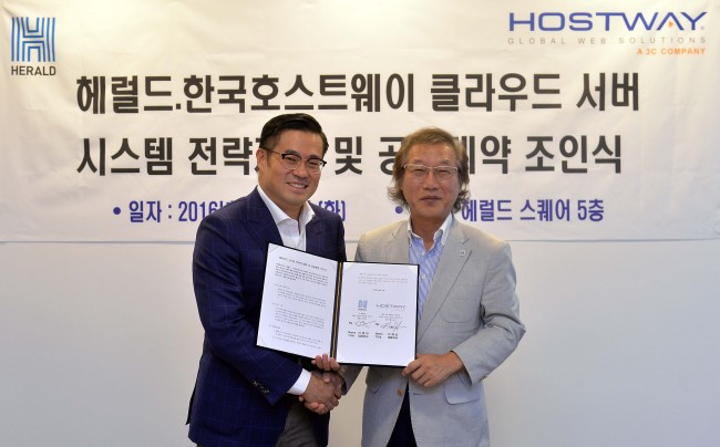 Herald Corp. CEO Lee Young-man (right) poses with Lee Han-joo, CEO of Hostway IDC, Inc. at Herald‘s headquarters in Yongsan, Seoul, Tuesday. Lee Sang-sub/The Korea Herald