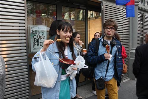French locals enjoy boiled fish cakes and corn dogs in the Korean street food festival held in Paris on Sept. 26, 2015. (Yonhap)