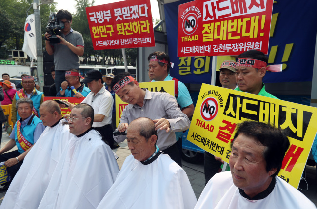 Gimcheon residents and city council members shave their heads in front of the Defense Ministry in Seoul on Thursday in protest to the potential deployment of THAAD near their city. (Yonhap)