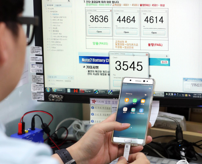 An engineer at a Samsung Electronics service center in downtown Seoul checks a Galaxy Note 7 smartphone`s battery voltage on Saturday. (Yonhap)