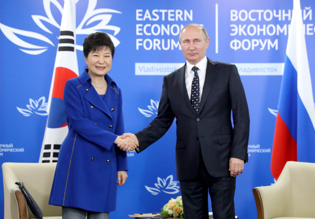 President Park Geun-hye (left) and her Russian counterpart Vladimir Putin shake hands during their summit on the sidelines of the Eastern Economic Forum in Vladivostok, Russia, Saturday. (Yonhap)