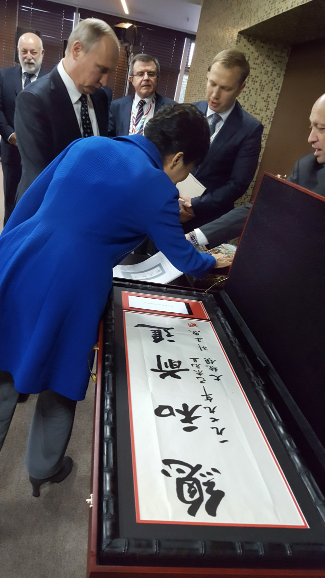 Photo taken on Sept. 3,and provided by the presidential office Cheong Wa Dae, shows President Park Geun-hye looking at the calligraphy of her late father and former President Park Chung-hee after a working luncheon at the Eastern Economic Forum in Russia's Far East port city of Vladivostok. (Yonhap)