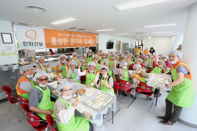 Employees and executives from Hanwha E&C make Korean rice cake songpyeon to share with those in need in Jung-gu, central Seoul, Wednesday. (Hanwha E&C)