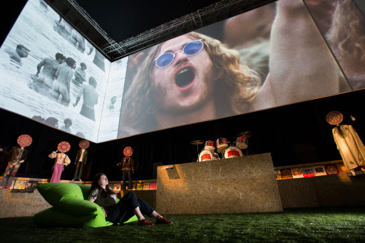 A V&A employee looks at a showreel projected to big screens during a photo-call for the “You Say You Want a Revolution? Records and Rebels 1966-70” exhibition at the V&A museum in central London on Wednesday. (AFP-Yonhap)