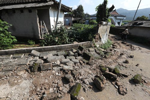 13일 오전 경북 경주 내남면 부지리의 한 주택에서 집주인이 전날 강진으로 무너진 담벼락을 바라보고 있다. (연합)