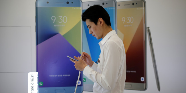 A salesperson uses a Galaxy Note 7 smartphone at a Samsung Electronics retail shop in Seoul.