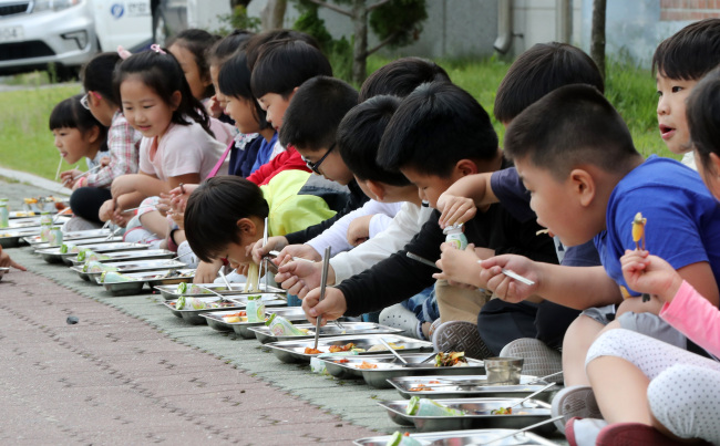 Students at Bulguksa primary school in Gyeongju, North Gyeongsang Province, have lunch on the playground outside their school as a 3.5 magnitude quake hit the region on Wednesday. Yonhap