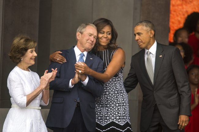 US first lady Michelle Obama hugs former President George W. Bush while President Barack Obama and former first Lady laura Bush look on at the opening of the Smithsonian’s National Museum of African American History and Culture in Washington on Saturday. EPA-Yonhap