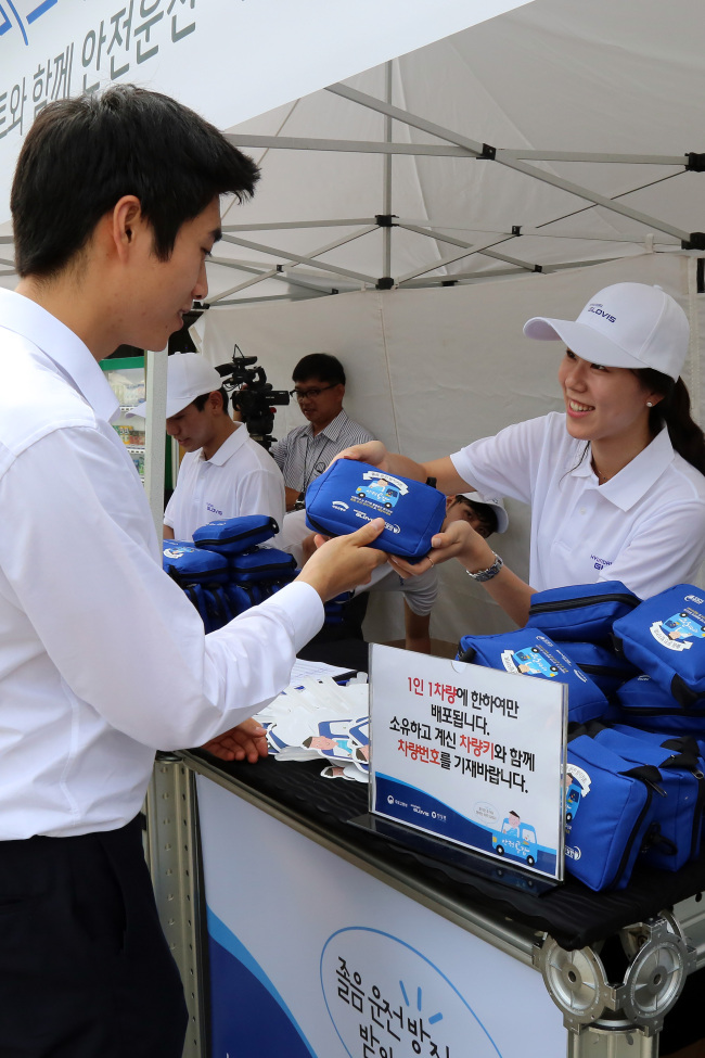 Officials at Hyundai Glovis distribute anti-drowsy kits for drivers at a highway rest stop. (Hyundai Glovis)