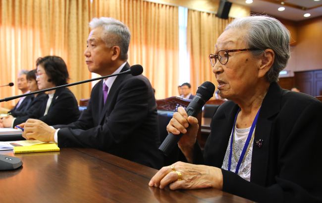 Kim Bok-dong (right), a victim of Japan`s sex slavery during World War II, speaks during a parliamentary audit at the Foreign Ministry on Monday, which was attended by Lee Sang-deok (second from right), Seoul`s ambassador to Singapore who had led negotiations with Japan on the issue as director-general for Northeast Asian affairs. (Yonhap)