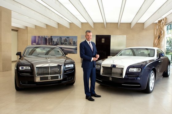 Rolls-Royce Motor Cars CEO Torsten Mueller Otvos poses with Rolls-Royce vehicles. Rolls-Royce Motor Cars