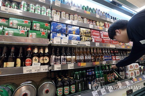 A shopper chooses a bottle of imported beer at a discount store in Seoul on March 30, 2016. (Yonhap)