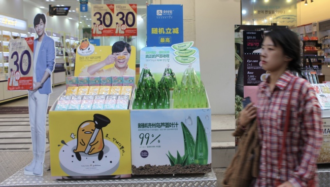 A passenger walks past cosmetic products featuring Jejudo aloe vera in Myeong-dong, a shopping hub in Seoul. (Park Ga-young/The Korea Herald)