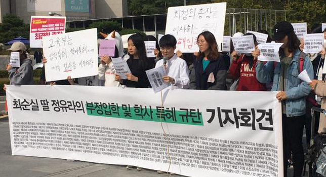 Members of Ewha Womans University‘s student council hold banners condemning the school‘s alleged admissions fraud and preferential treatment to the daughter of Choi Soon-sil, a close friend of President Park Geun-hye, at the university campus in Seoul on Monday. (Yonhap)