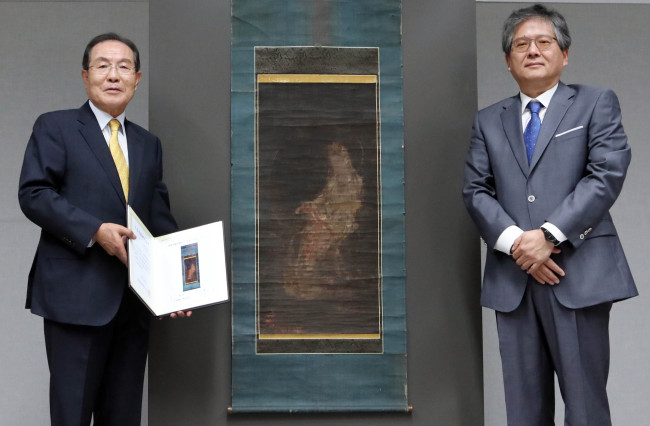 Kolmar Korea Chairman Yoon Dong-han (left) and Lee Young-hong, director of the National Museum of Korea, pose in front of “Water-Moon Avalokiteshvara” at a press conference held at the museum in Seoul on Monday. (Yonhap)