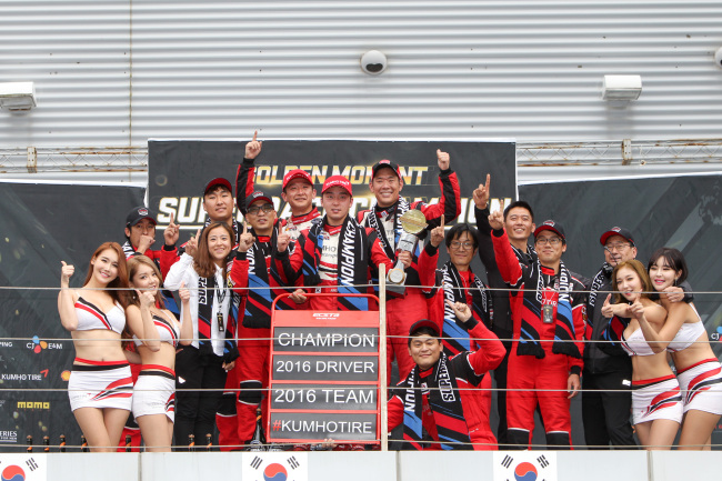 Kumho Tire Ecsta Racing Team members and models pose for a photo at the Korea International Circuit held in Yeongam, South Jeolla Province, Sunday. (Kumho Tire)