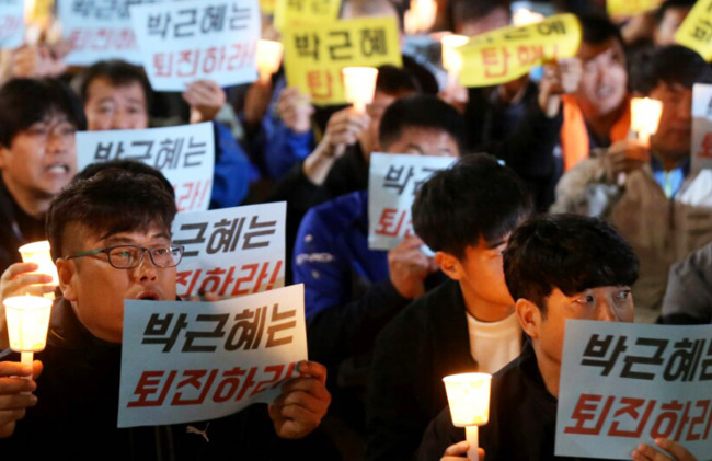 Participants hold candles and signs reading, “Park Geun-hye, resign!” in a candlelight vigil held in Suwon, Gyeonggi Province, Wednesday. (Yonhap)